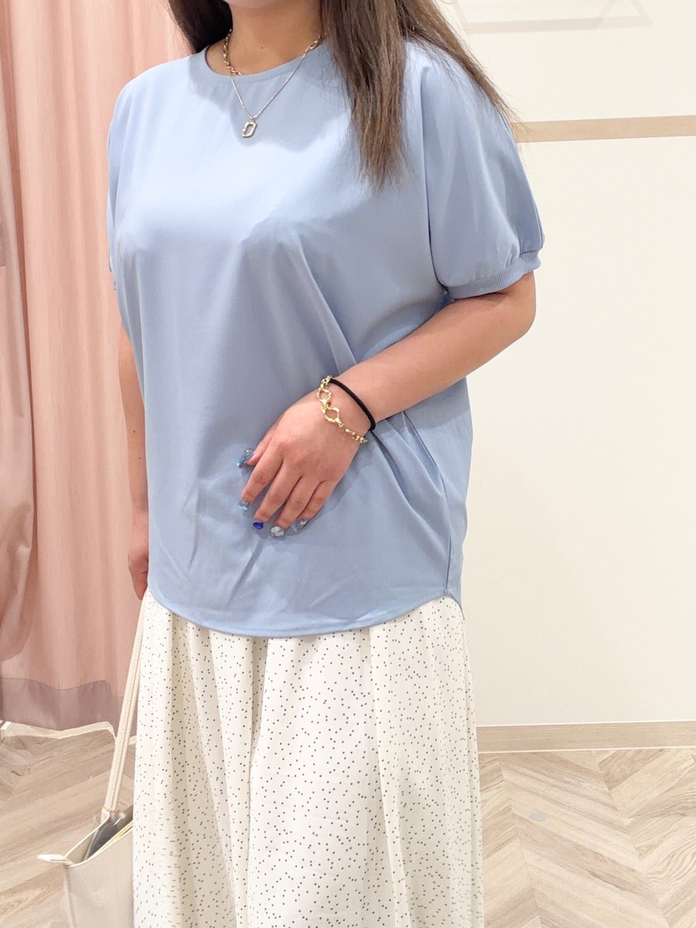 レッド系のニット/セーター、ホワイト系のスカート、ブルー系のシャツ/ブラウスを着用したレディースの春コーディネートの5枚目の写真