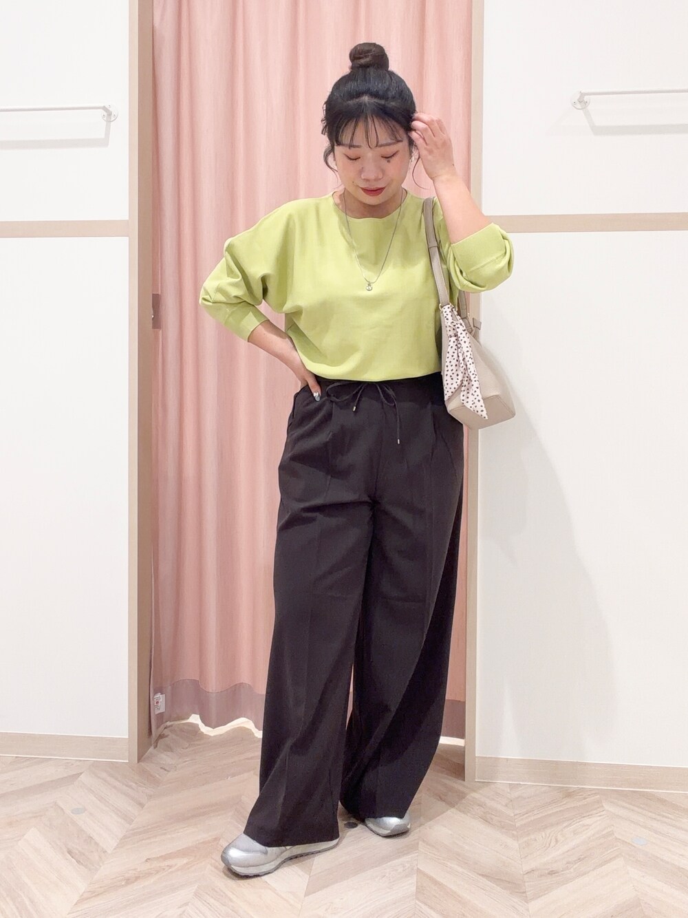 グリーン系のニット/セーター、ブラック系のその他パンツ、ベージュ系のショルダーバッグを着用したレディースの春コーディネートの2枚目の写真