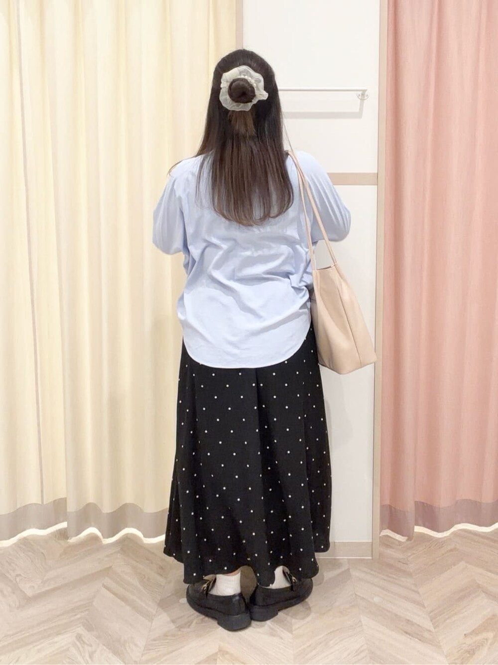 ブルー系のシャツ/ブラウス、ブラック系のスカート、ホワイト系のトートバッグを着用したレディースの春コーディネートの5枚目の写真