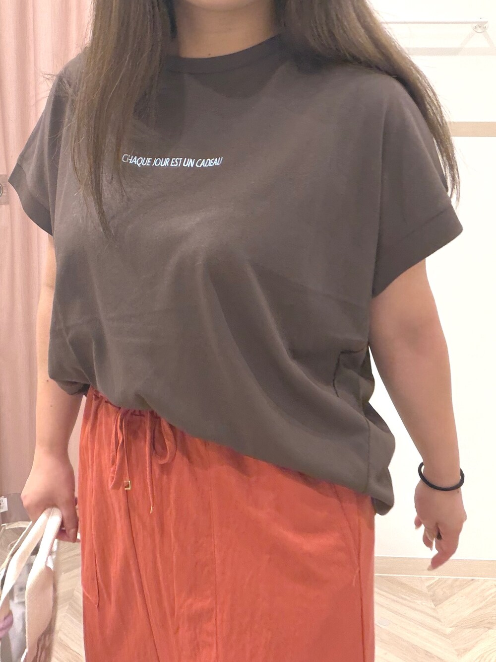ブラウン系のTシャツ/カットソー、レッド系のスカート、ブラック系のサンダルを着用したレディースの夏コーディネートの8枚目の写真