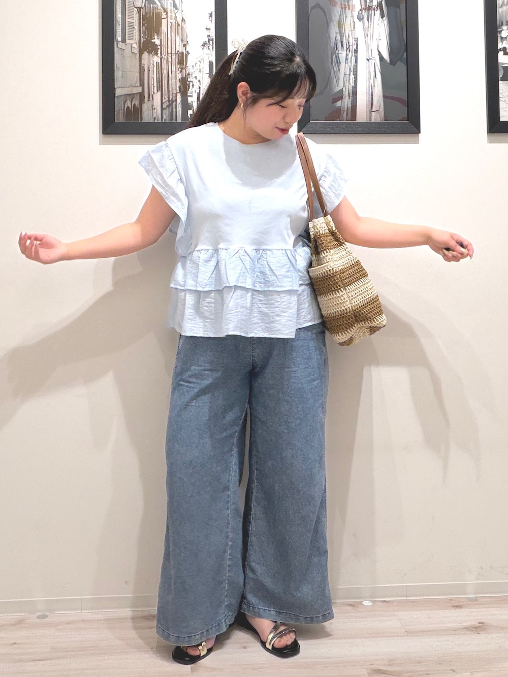 ブルー系のTシャツ/カットソー、ブルー系のデニムパンツ、ベージュ系のトートバッグを着用したレディースの夏コーディネートの2枚目の写真
