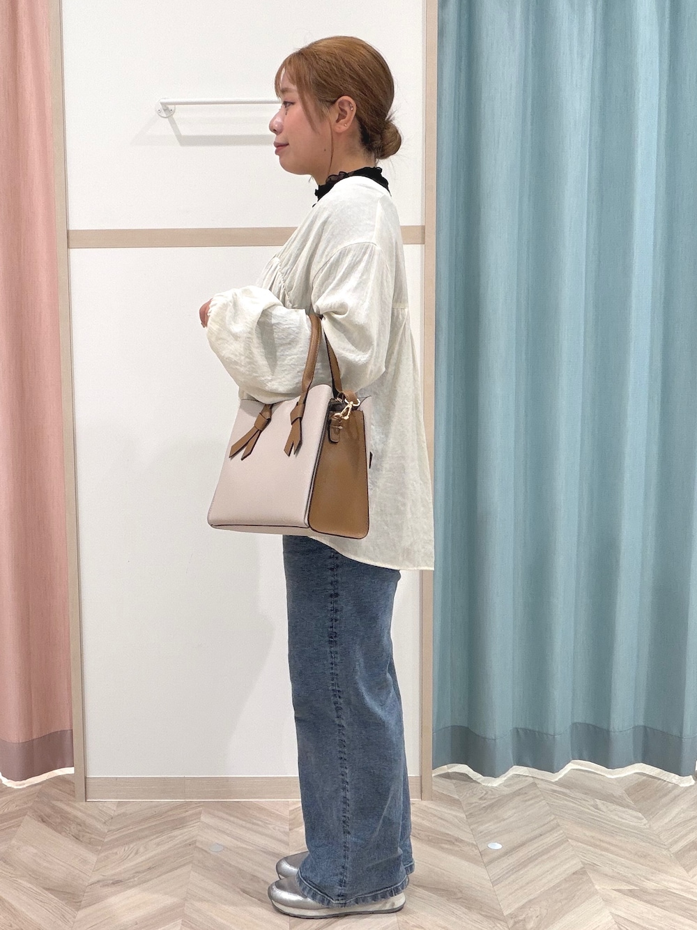 ブラック系のTシャツ/カットソー、ホワイト系のカーディガン/ボレロ、ブルー系のデニムパンツを着用したレディースの秋コーディネートの4枚目の写真