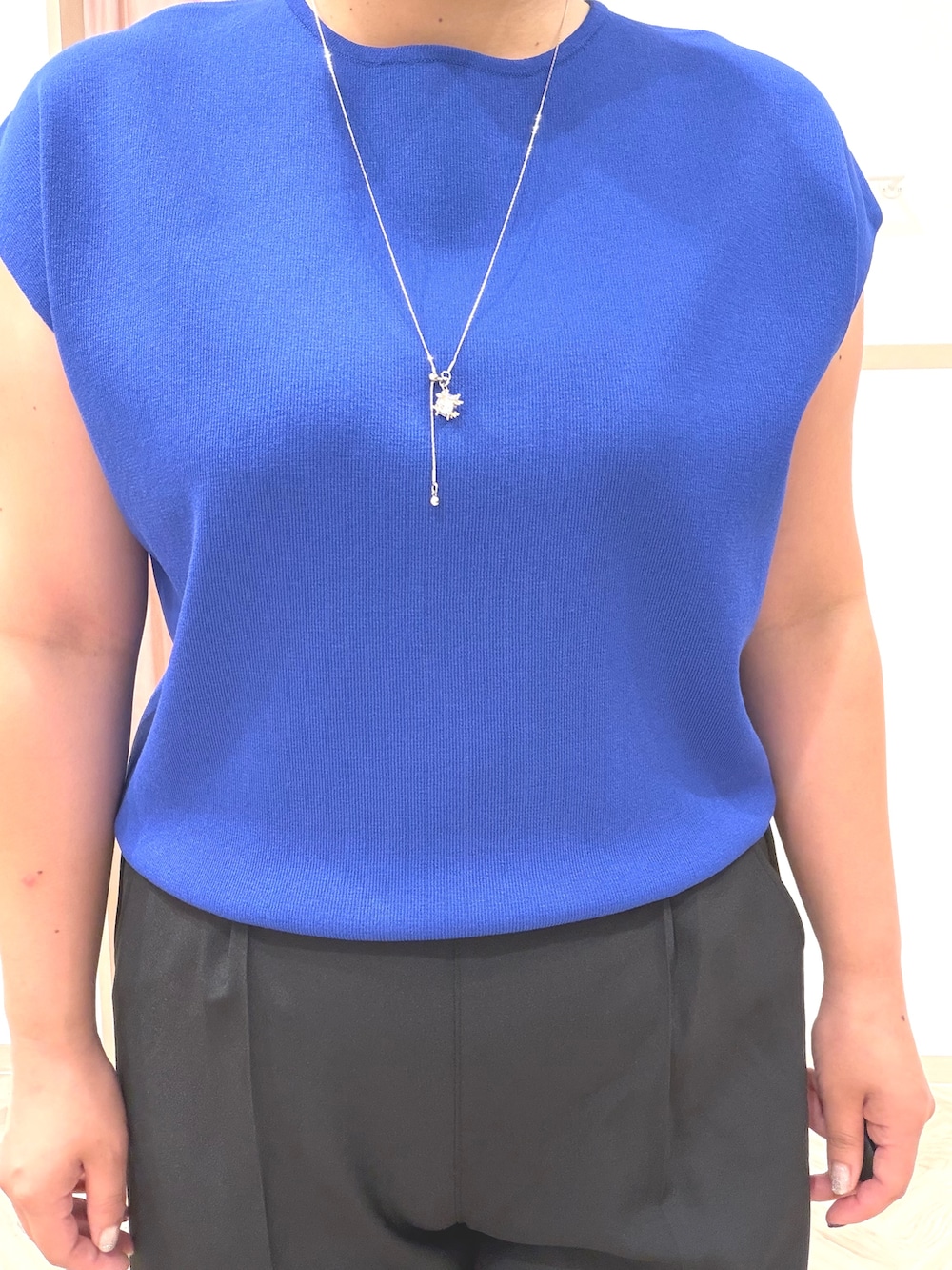 ブルー系のニット/セーター、ブラック系のその他パンツ、ブラック系のサンダルを着用したレディースの夏コーディネートの6枚目の写真