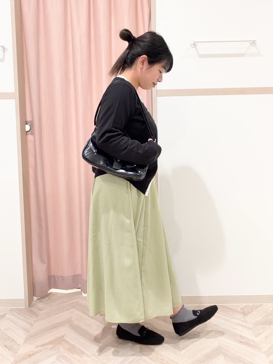 ブラック系のニット/セーター、ブラック系のカーディガン/ボレロ、グリーン系のスカートを着用したレディースの冬コーディネートの2枚目の写真