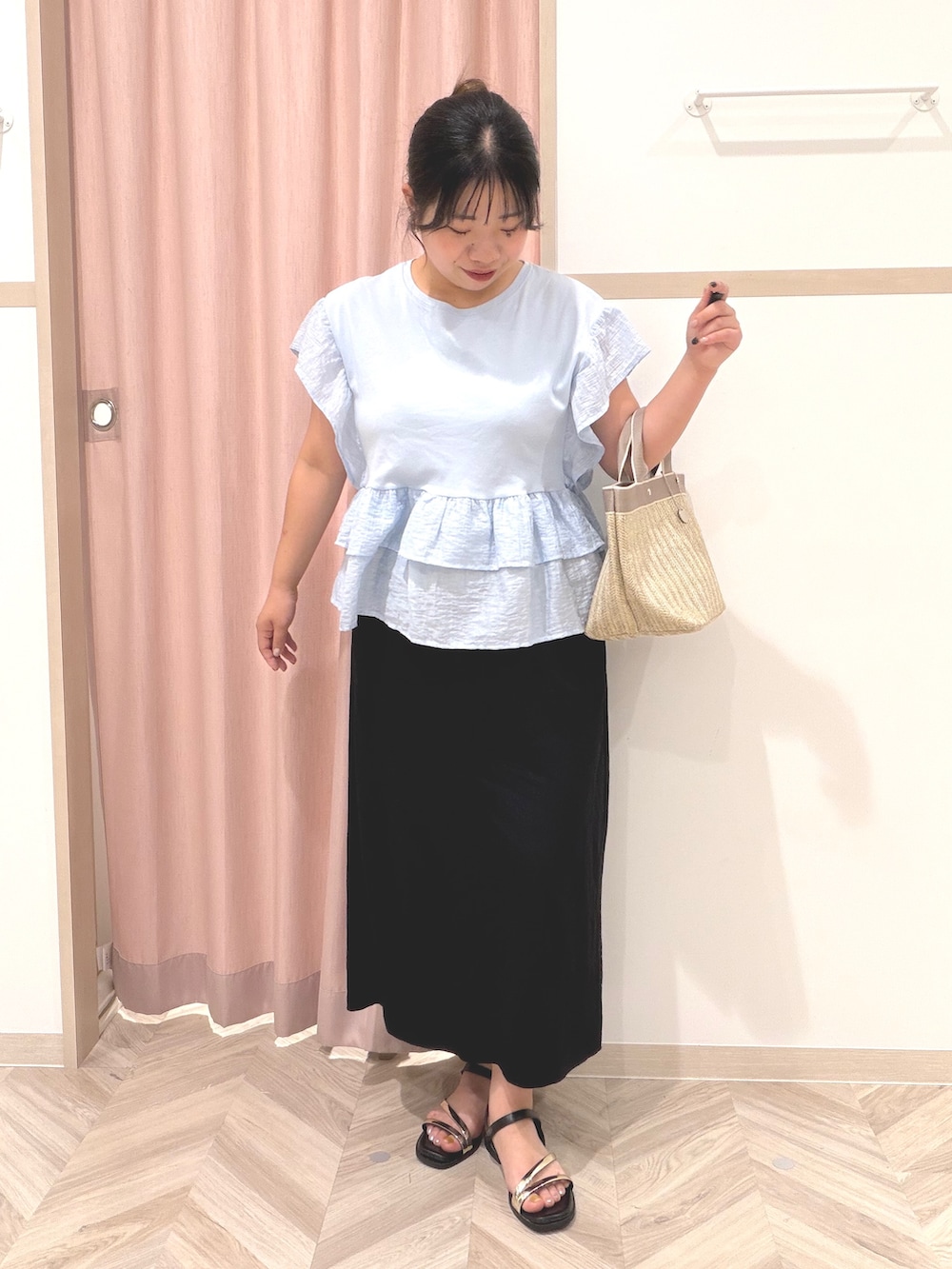ブルー系のTシャツ/カットソー、ブラック系のスカート、ベージュ系のトートバッグを着用したレディースの夏コーディネートの2枚目の写真