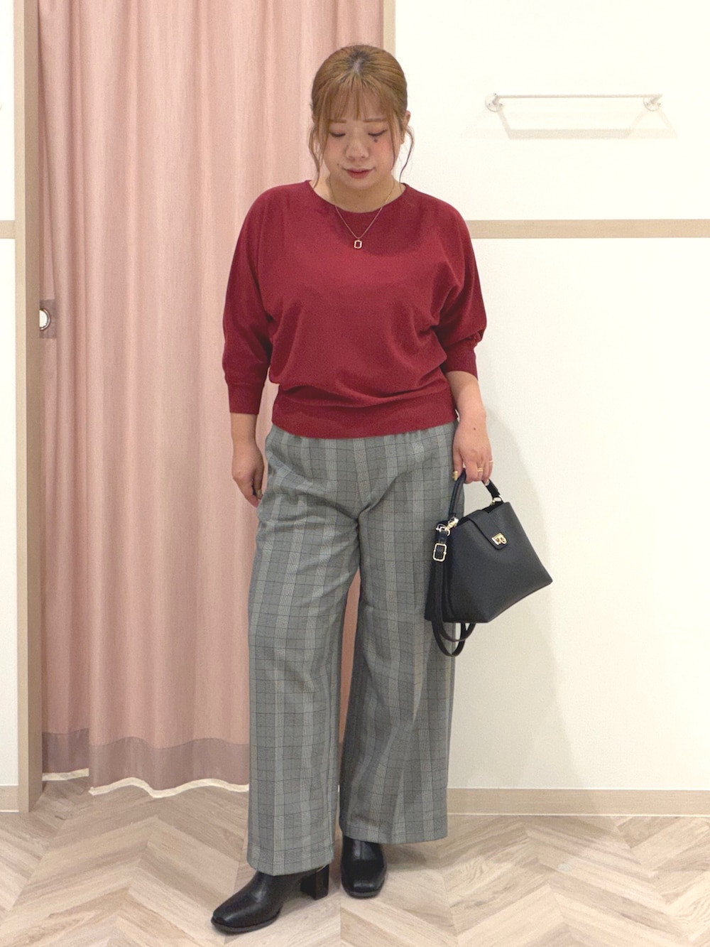 レッド系のニット/セーター、グレー系のその他パンツ、ブラック系のブーツを着用したレディースの秋コーディネートの8枚目の写真