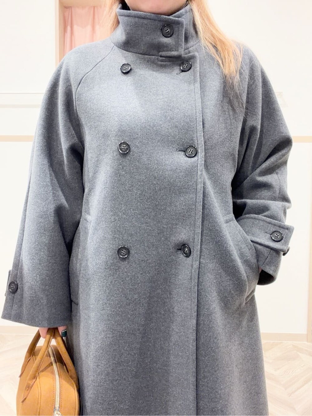 グレー系のその他アウター、オレンジ系のニット/セーター、グレー系のその他パンツを着用したレディースの冬コーディネートの9枚目の写真
