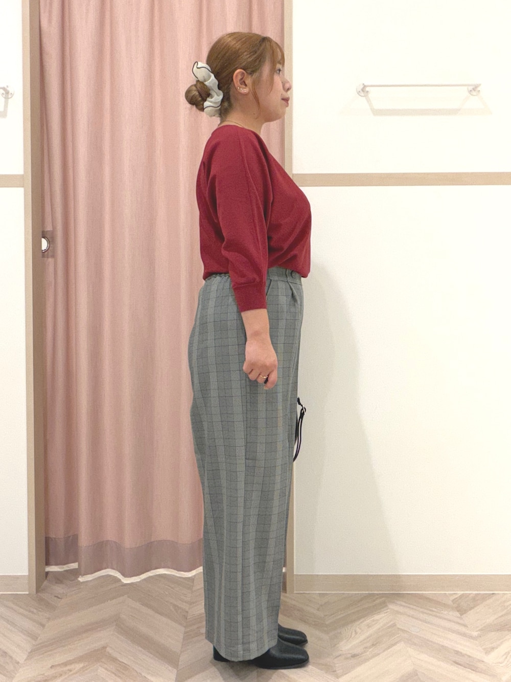レッド系のニット/セーター、グレー系のその他パンツ、ブラック系のブーツを着用したレディースの秋コーディネートの3枚目の写真