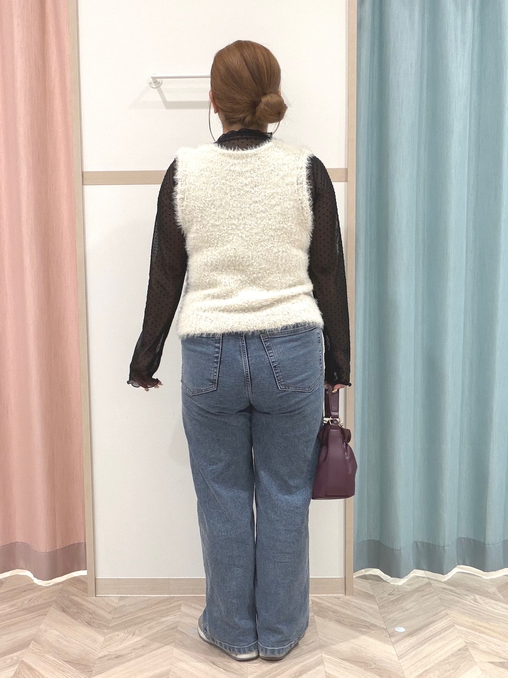 ブラック系のTシャツ/カットソー、ホワイト系のベスト、ブルー系のデニムパンツを着用したレディースの秋コーディネートの5枚目の写真