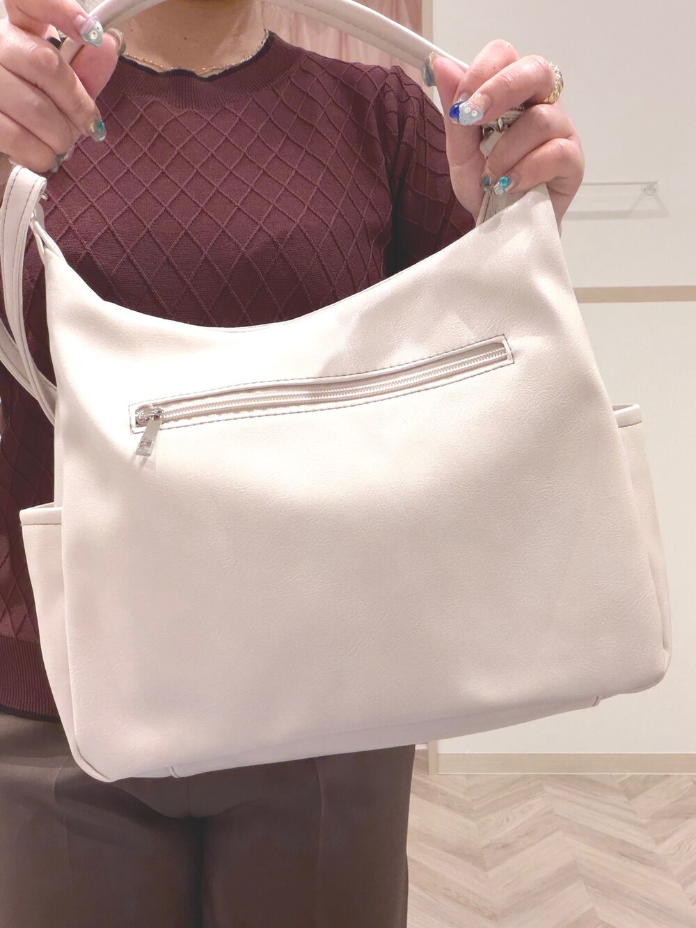 レッド系のニット/セーター、ブラウン系のその他パンツ、ブラック系のその他シューズを着用したレディースの夏コーディネートの9枚目の写真