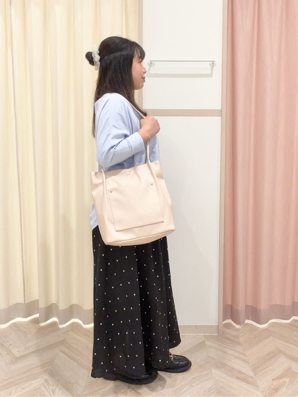 ブルー系のシャツ/ブラウス、ブラック系のスカート、ホワイト系のトートバッグを着用したレディースの春コーディネートの3枚目の写真