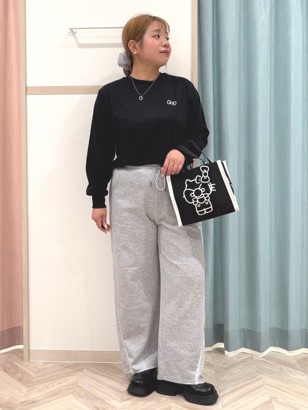ブラック系のTシャツ/カットソー、グレー系のその他パンツ、ブラック系のブーツを着用したレディースの秋コーディネートの2枚目の写真