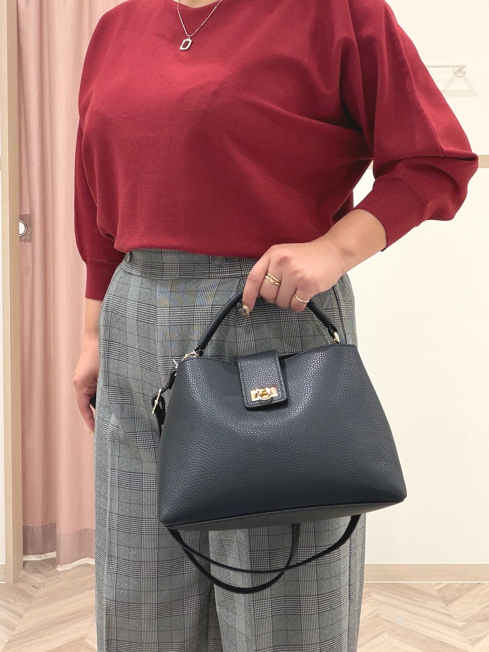 レッド系のニット/セーター、グレー系のその他パンツ、ブラック系のブーツを着用したレディースの秋コーディネートの6枚目の写真