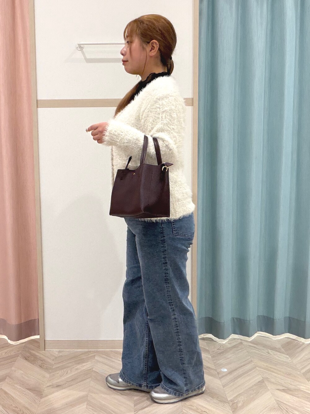 ブラック系のTシャツ/カットソー、ホワイト系のニット/セーター、ブルー系のデニムパンツを着用したレディースの秋コーディネートの5枚目の写真