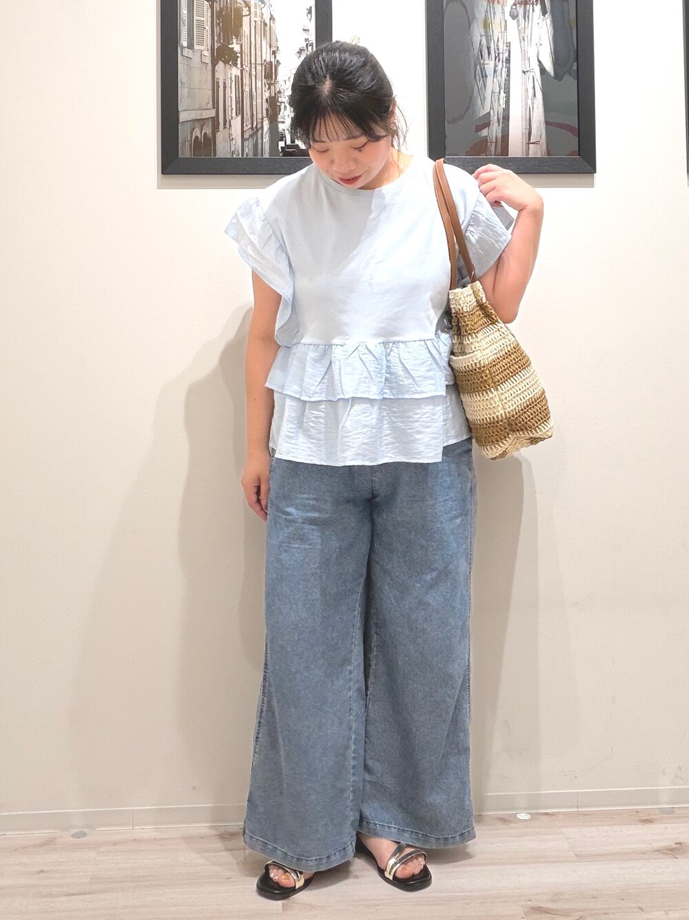 ブルー系のTシャツ/カットソー、ブルー系のデニムパンツ、ベージュ系のトートバッグを着用したレディースの夏コーディネートの3枚目の写真