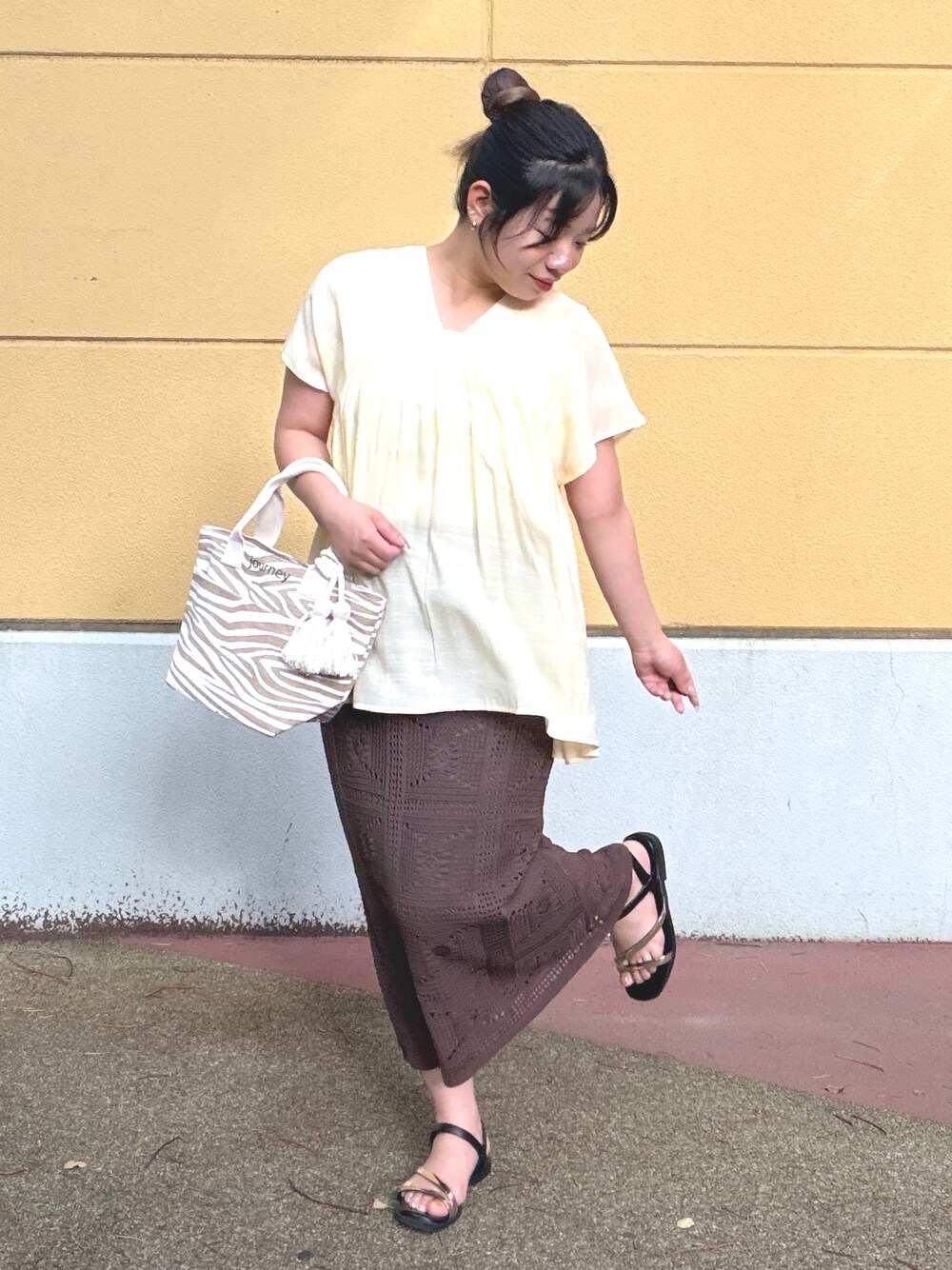 ホワイト系のタンクトップ、イエロー系のシャツ/ブラウス、ブラウン系のスカートを着用したレディースの夏コーディネートの3枚目の写真