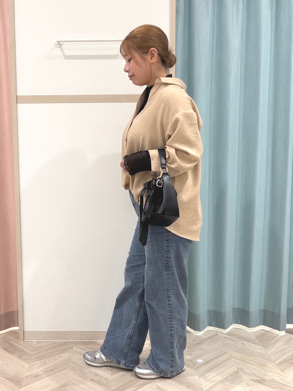 ブラック系のTシャツ/カットソー、ベージュ系のシャツ/ブラウス、ブルー系のデニムパンツを着用したレディースの秋コーディネートの4枚目の写真