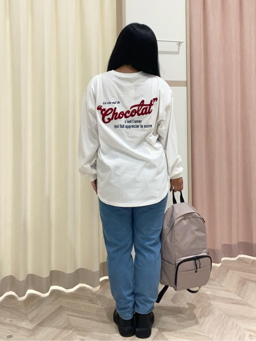 ホワイト系のTシャツ/カットソー、ブルー系のデニムパンツ、ブラック系のブーツを着用したレディースの秋コーディネートの4枚目の写真