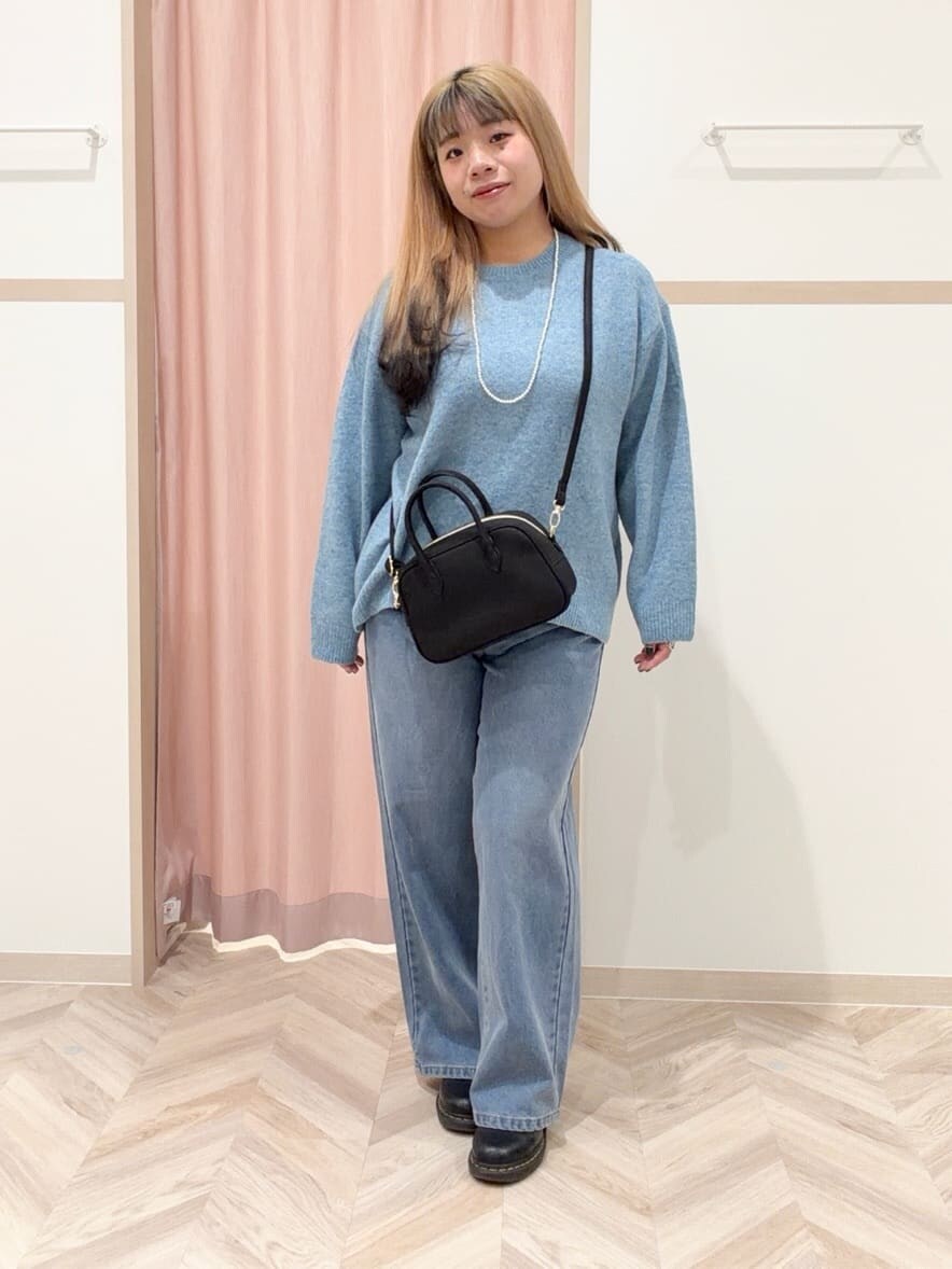 ブルー系のニット/セーター、ブルー系のデニムパンツ、ブラック系のボストンバッグを着用したレディースの冬コーディネートの3枚目の写真