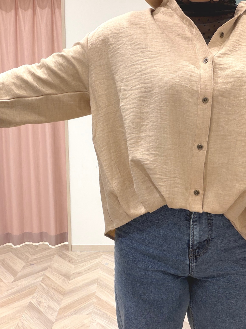 ブラック系のTシャツ/カットソー、ベージュ系のシャツ/ブラウス、ブルー系のデニムパンツを着用したレディースの秋コーディネートの6枚目の写真