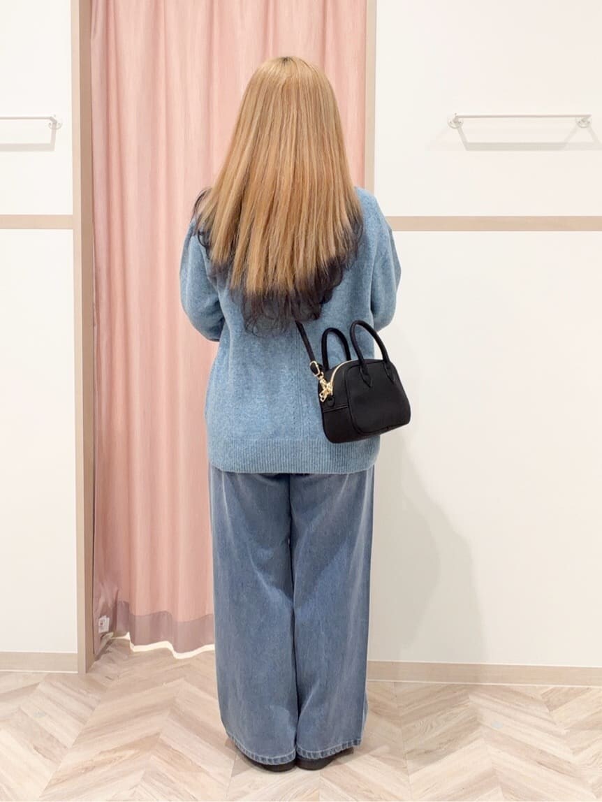 ブルー系のニット/セーター、ブルー系のデニムパンツ、ブラック系のボストンバッグを着用したレディースの冬コーディネートの5枚目の写真