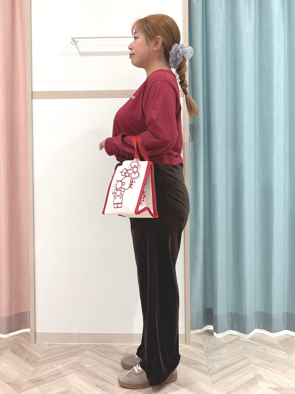 レッド系のTシャツ/カットソー、ブラウン系のその他パンツ、ベージュ系のスニーカーを着用したレディースの秋コーディネートの5枚目の写真