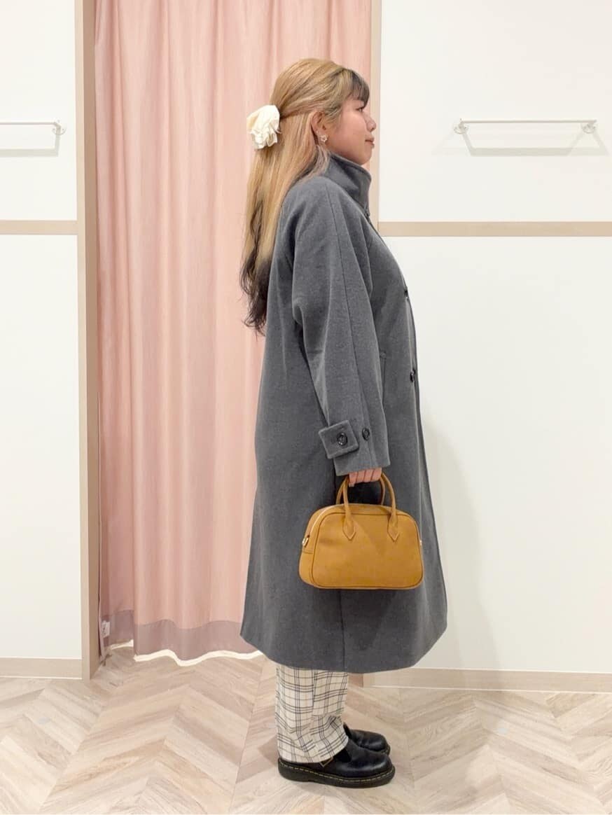 グレー系のその他アウター、オレンジ系のニット/セーター、グレー系のその他パンツを着用したレディースの冬コーディネートの7枚目の写真
