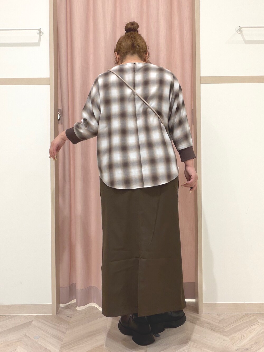 ベージュ系のシャツ/ブラウス、ブラック系のブーツ、ベージュ系のショルダーバッグを着用したレディースの秋コーディネートの5枚目の写真