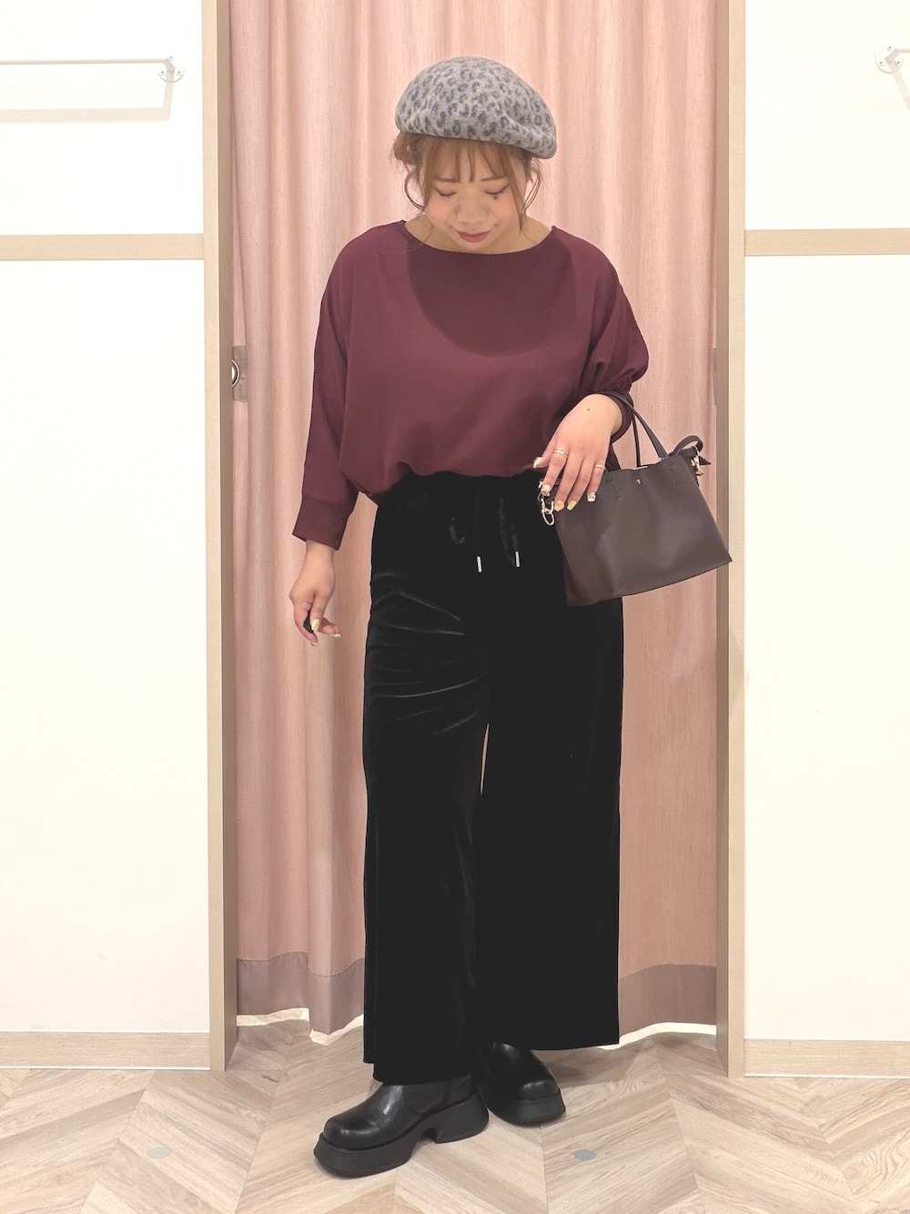 レッド系のシャツ/ブラウス、ブラック系のブーツ、レッド系のトートバッグを着用したレディースの秋コーディネートの2枚目の写真