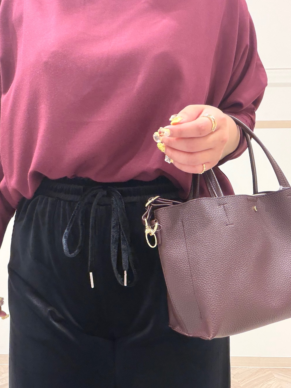 レッド系のシャツ/ブラウス、ブラック系のブーツ、レッド系のトートバッグを着用したレディースの秋コーディネートの6枚目の写真
