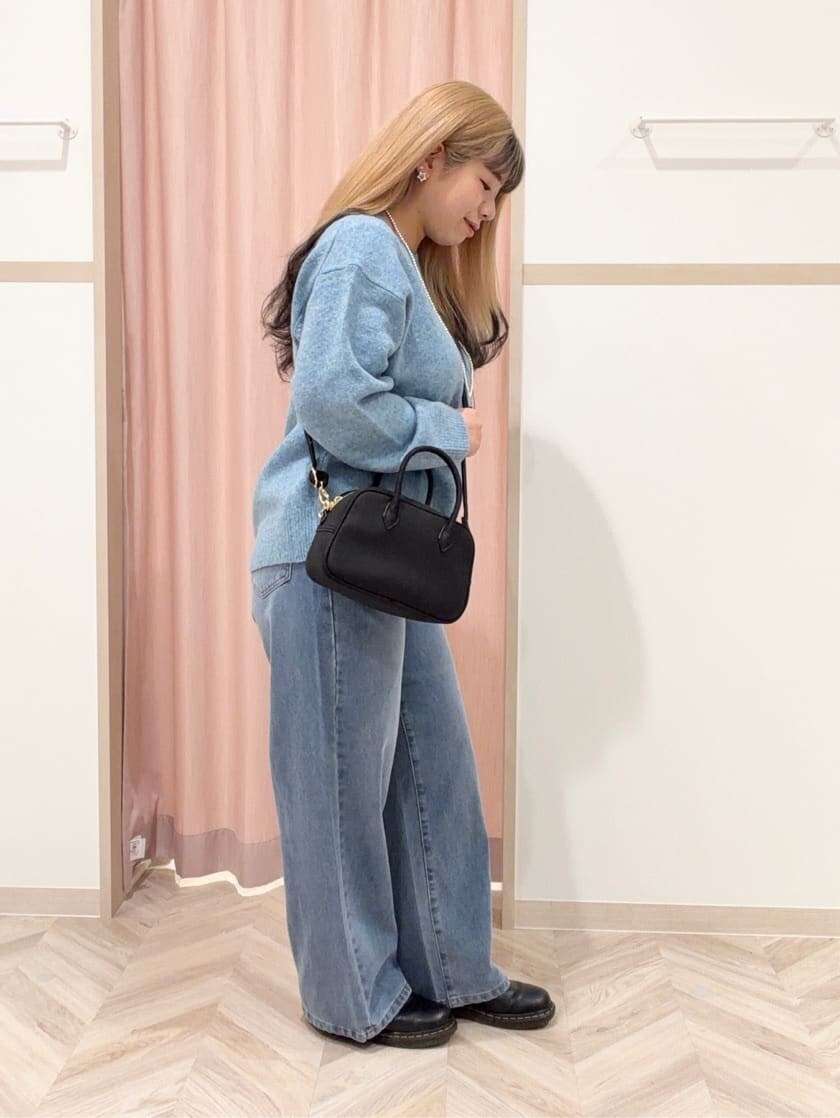 ブルー系のニット/セーター、ブルー系のデニムパンツ、ブラック系のボストンバッグを着用したレディースの冬コーディネートの4枚目の写真
