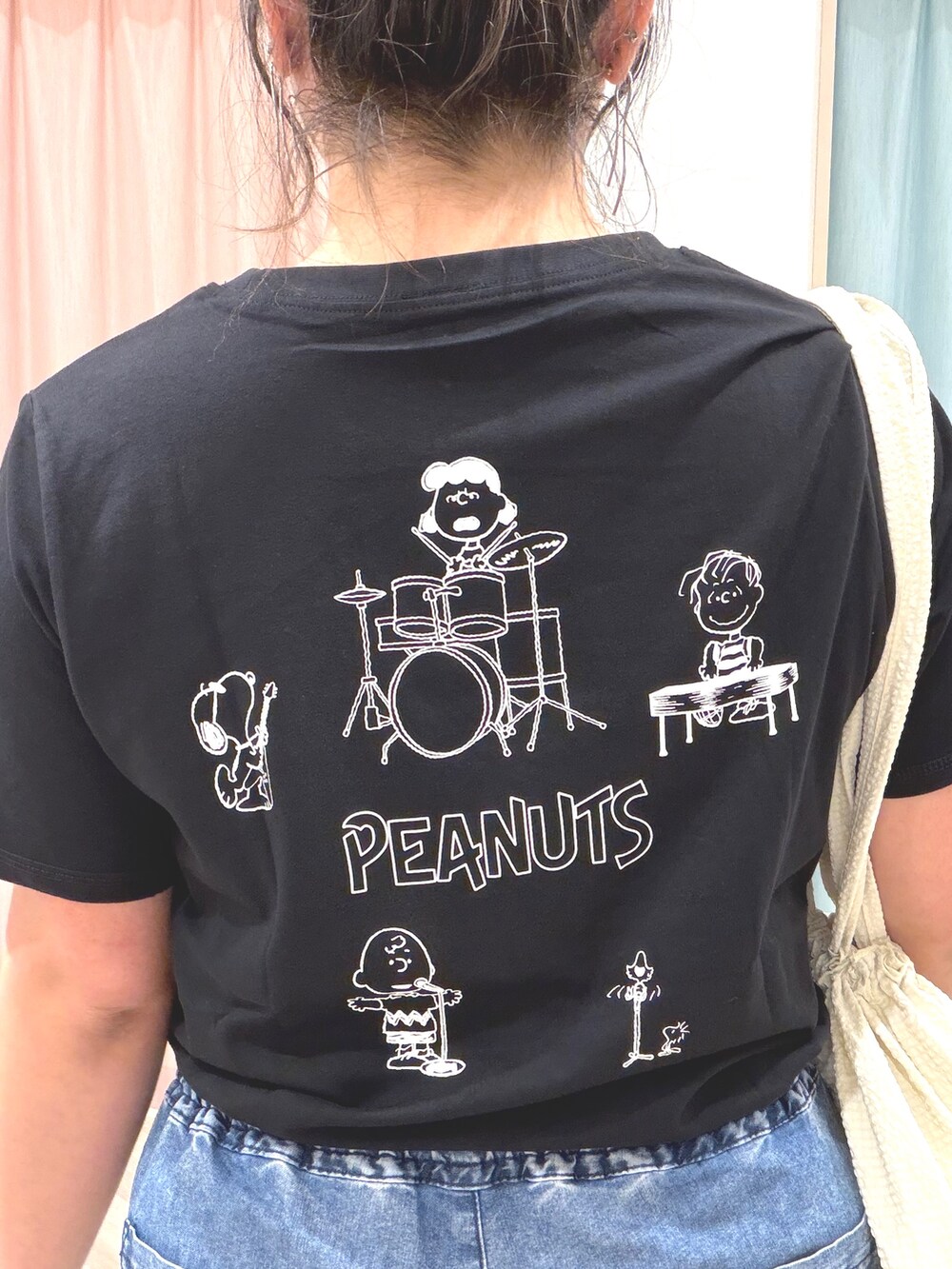 ブラック系のTシャツ/カットソー、ブルー系のデニムパンツ、ホワイト系のトートバッグを着用したレディースの夏コーディネートの6枚目の写真