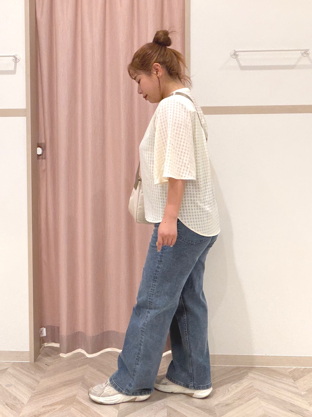 ゴールド系のタンクトップ、ホワイト系のシャツ/ブラウス、ブルー系のデニムパンツを着用したレディースの夏コーディネートの5枚目の写真