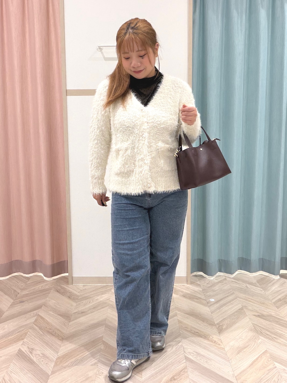 ブラック系のTシャツ/カットソー、ホワイト系のニット/セーター、ブルー系のデニムパンツを着用したレディースの秋コーディネートの2枚目の写真
