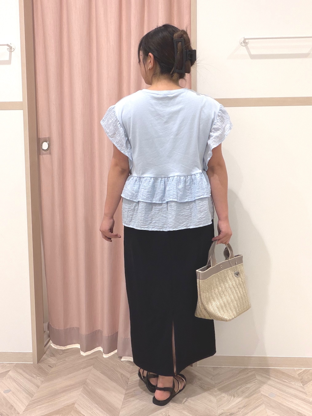 ブルー系のTシャツ/カットソー、ブラック系のスカート、ベージュ系のトートバッグを着用したレディースの夏コーディネートの4枚目の写真