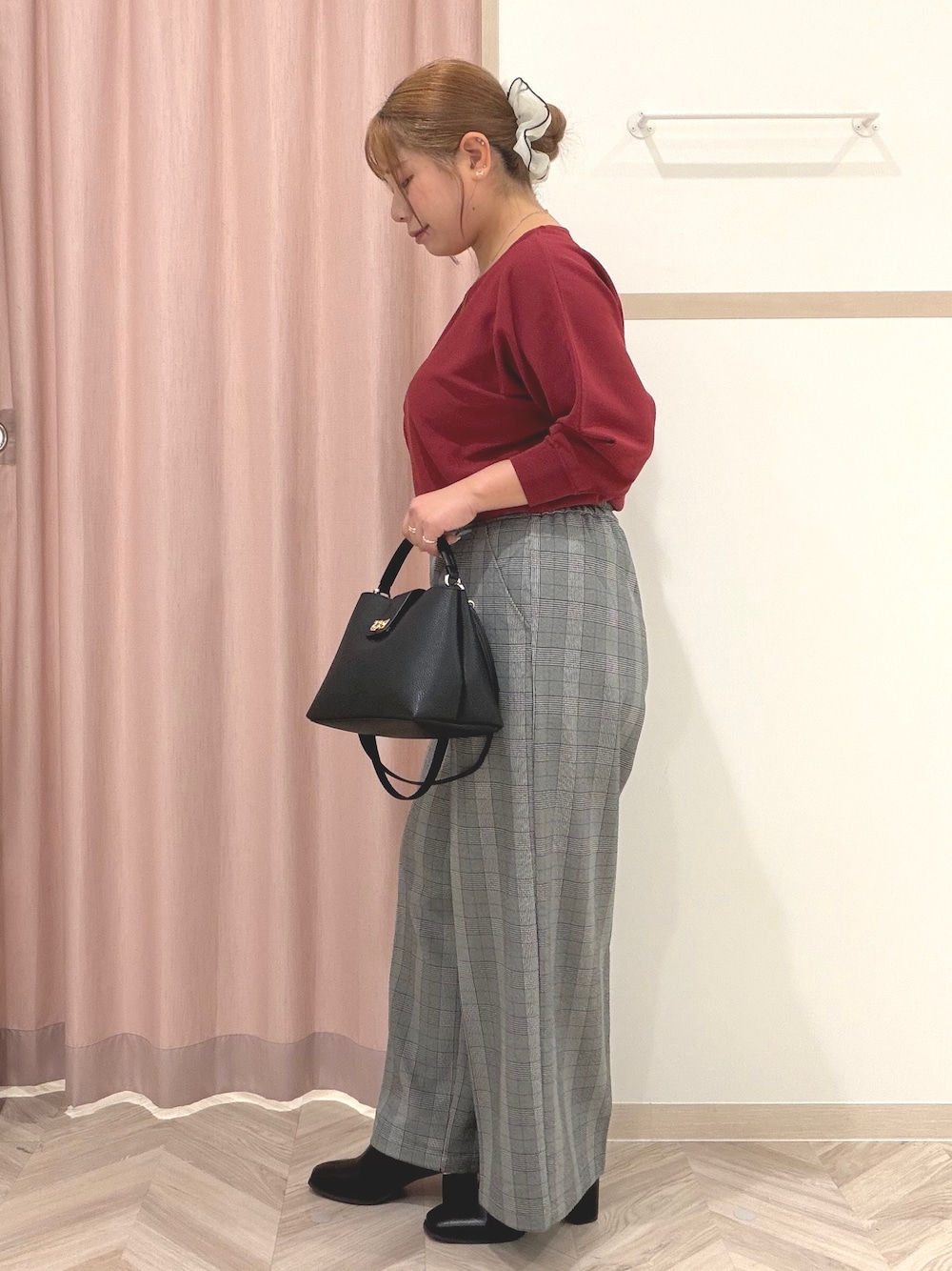 レッド系のニット/セーター、グレー系のその他パンツ、ブラック系のブーツを着用したレディースの秋コーディネートの4枚目の写真