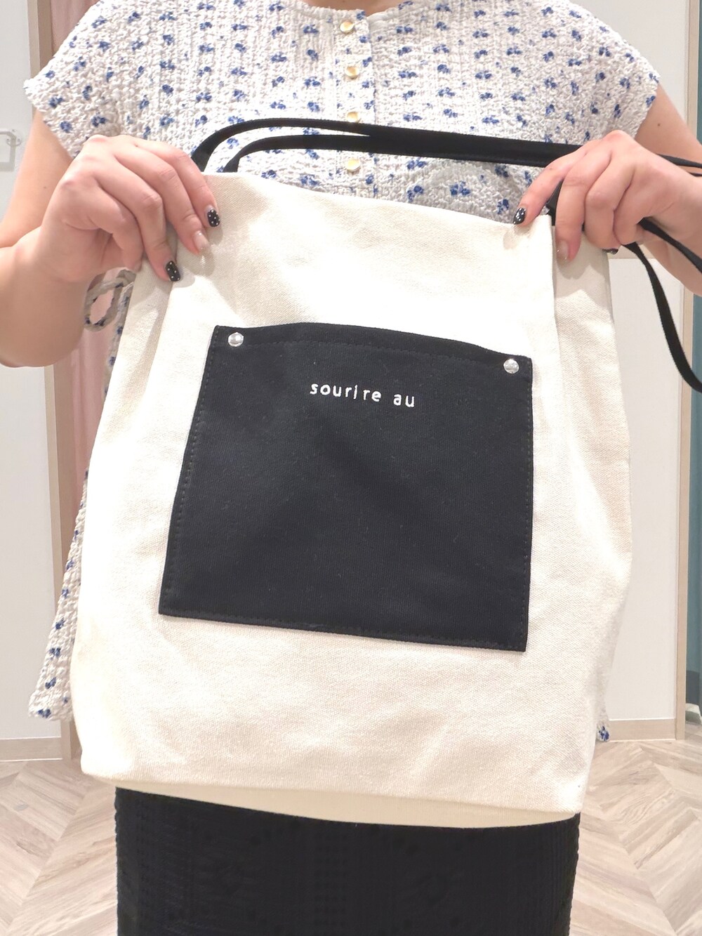 グレー系のTシャツ/カットソー、ブラック系のスカート、ホワイト系のトートバッグを着用したレディースの夏コーディネートの9枚目の写真