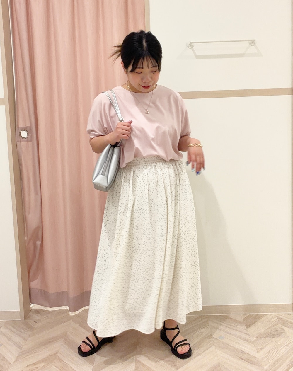 ピンク系のシャツ/ブラウス、ホワイト系のスカート、シルバー系のショルダーバッグを着用したレディースの春コーディネートの2枚目の写真