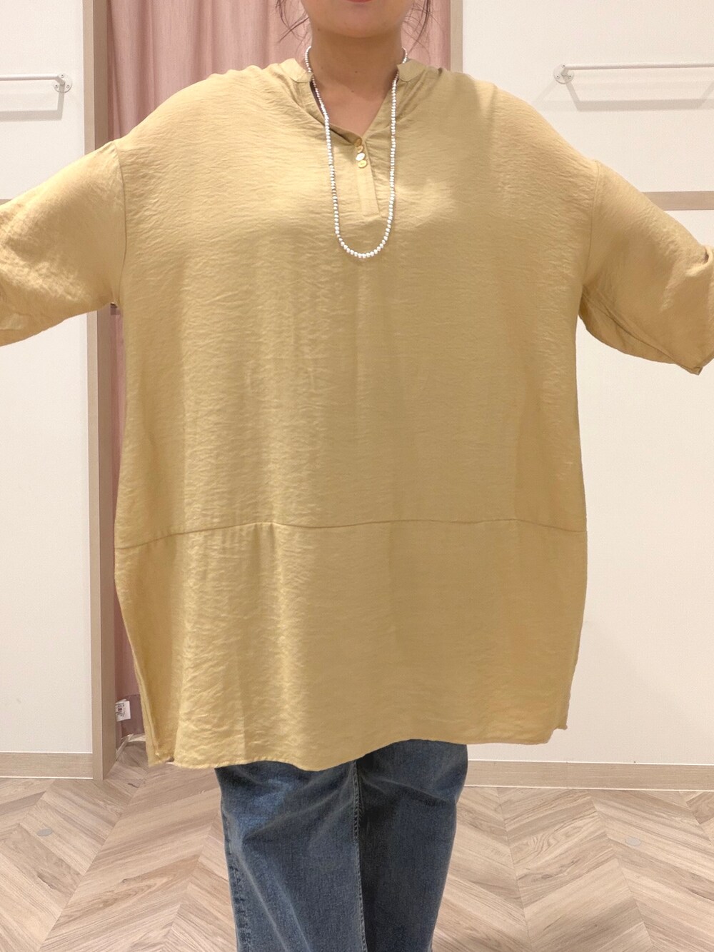 イエロー系のワンピース、ブルー系のデニムパンツ、ベージュ系のショルダーバッグを着用したレディースの夏コーディネートの9枚目の写真