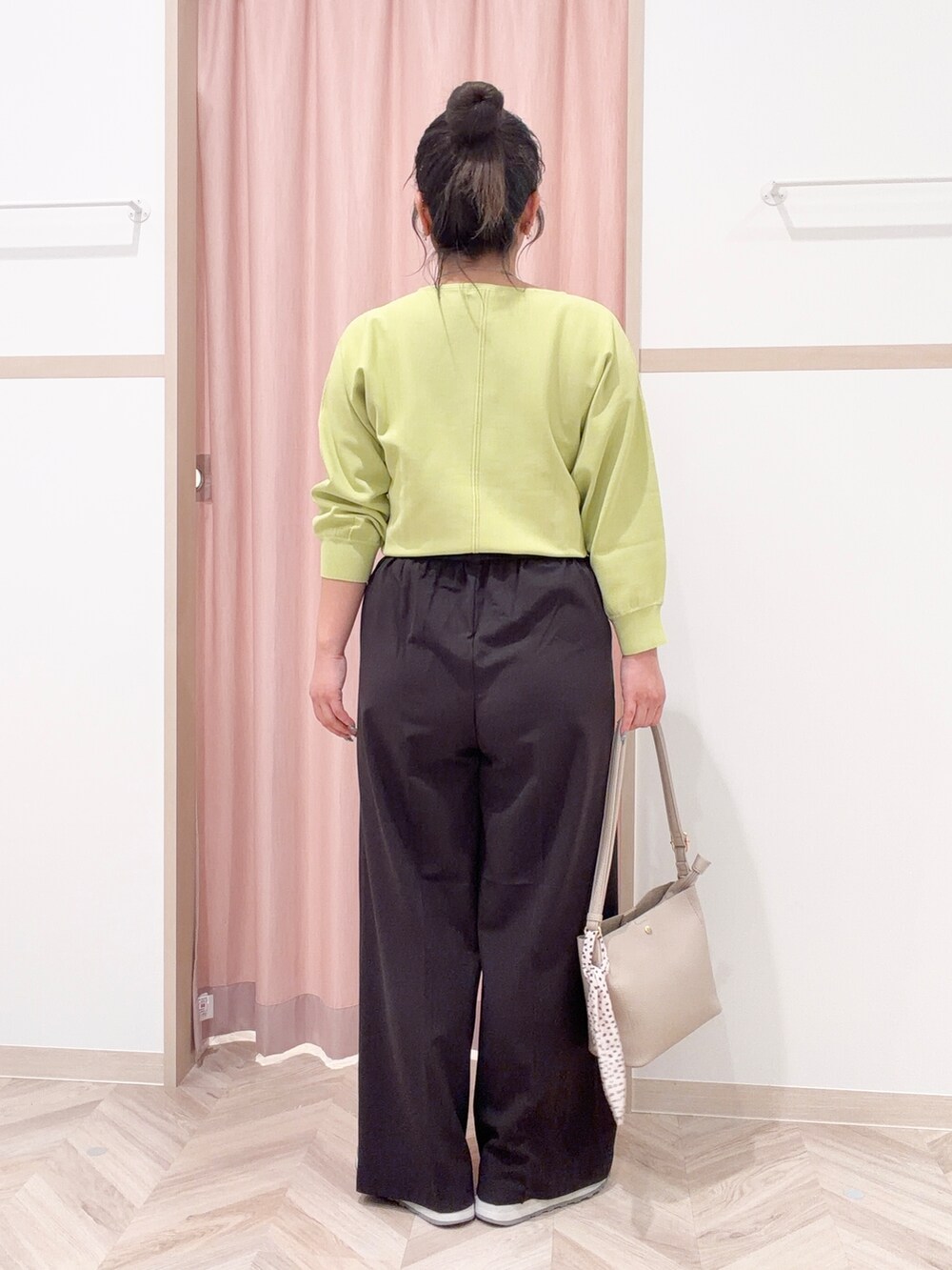 グリーン系のニット/セーター、ブラック系のその他パンツ、ベージュ系のショルダーバッグを着用したレディースの春コーディネートの5枚目の写真