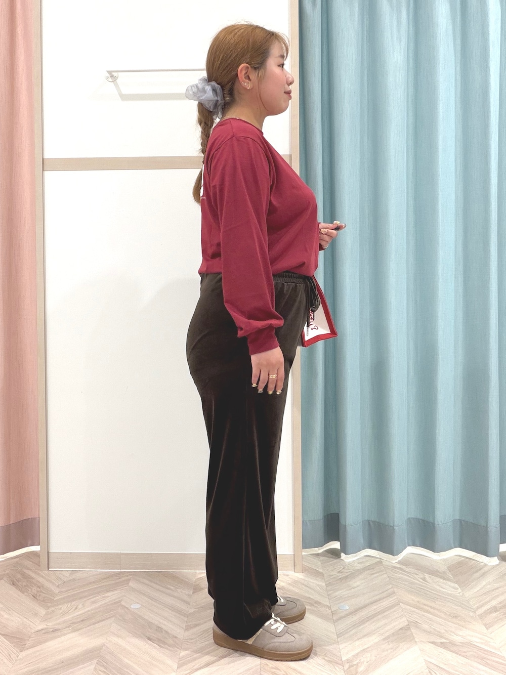 レッド系のTシャツ/カットソー、ブラウン系のその他パンツ、ベージュ系のスニーカーを着用したレディースの秋コーディネートの4枚目の写真