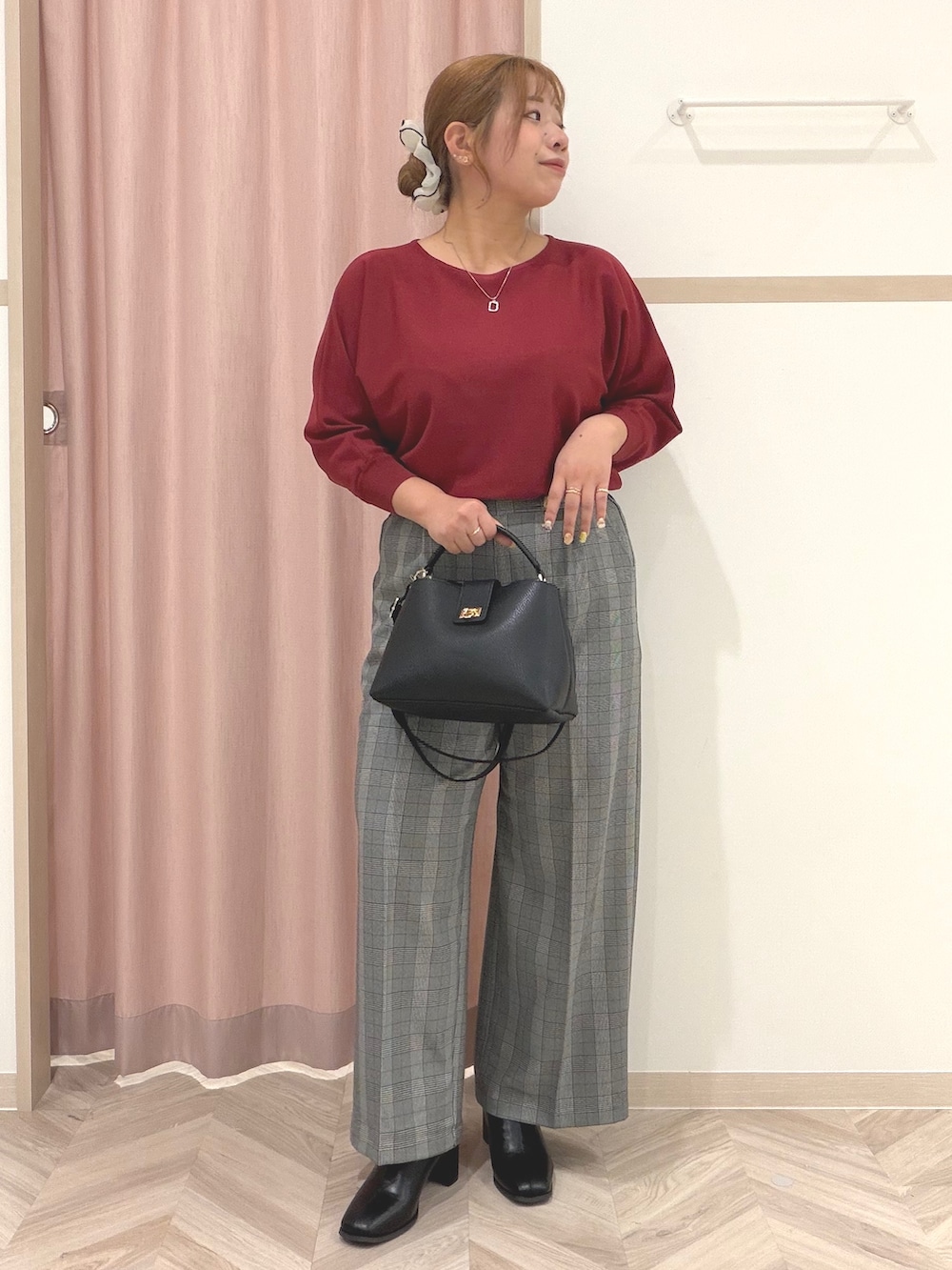 レッド系のニット/セーター、グレー系のその他パンツ、ブラック系のブーツを着用したレディースの秋コーディネートの2枚目の写真