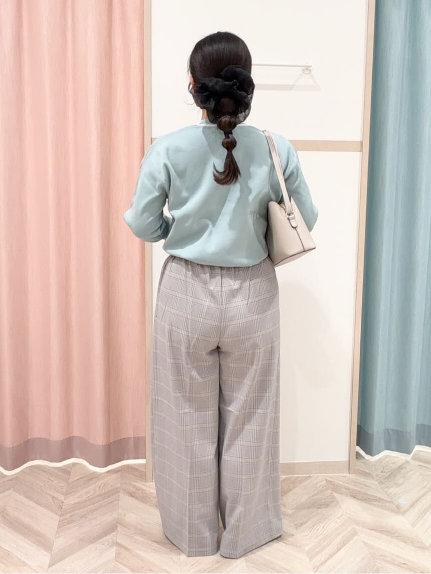 グリーン系のニット/セーター、ブラック系のその他パンツ、ブラック系のパンプスを着用したレディースの冬コーディネートの5枚目の写真