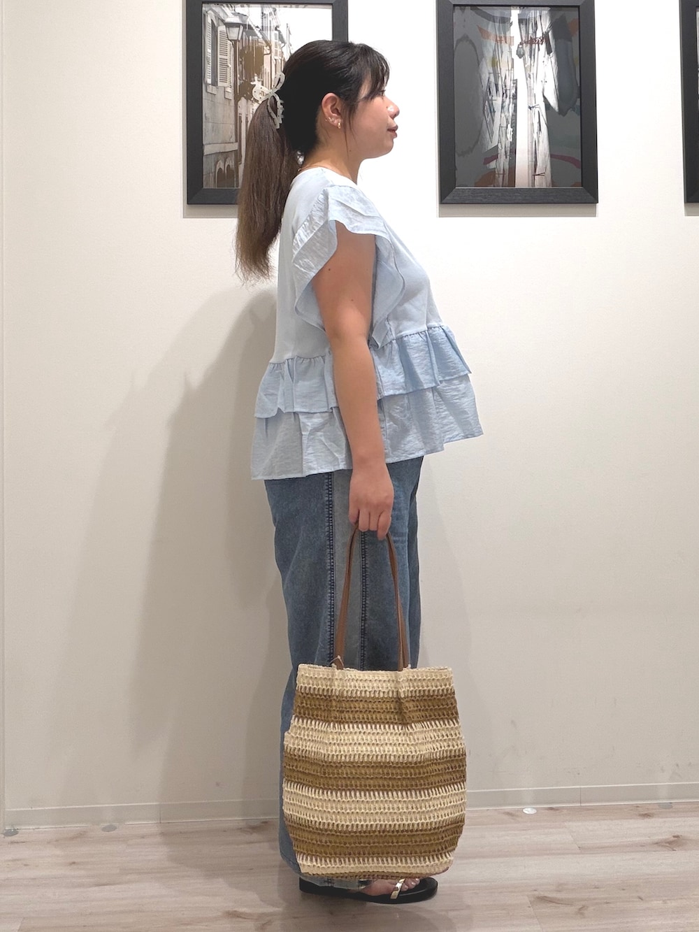 ブルー系のTシャツ/カットソー、ブルー系のデニムパンツ、ベージュ系のトートバッグを着用したレディースの夏コーディネートの4枚目の写真