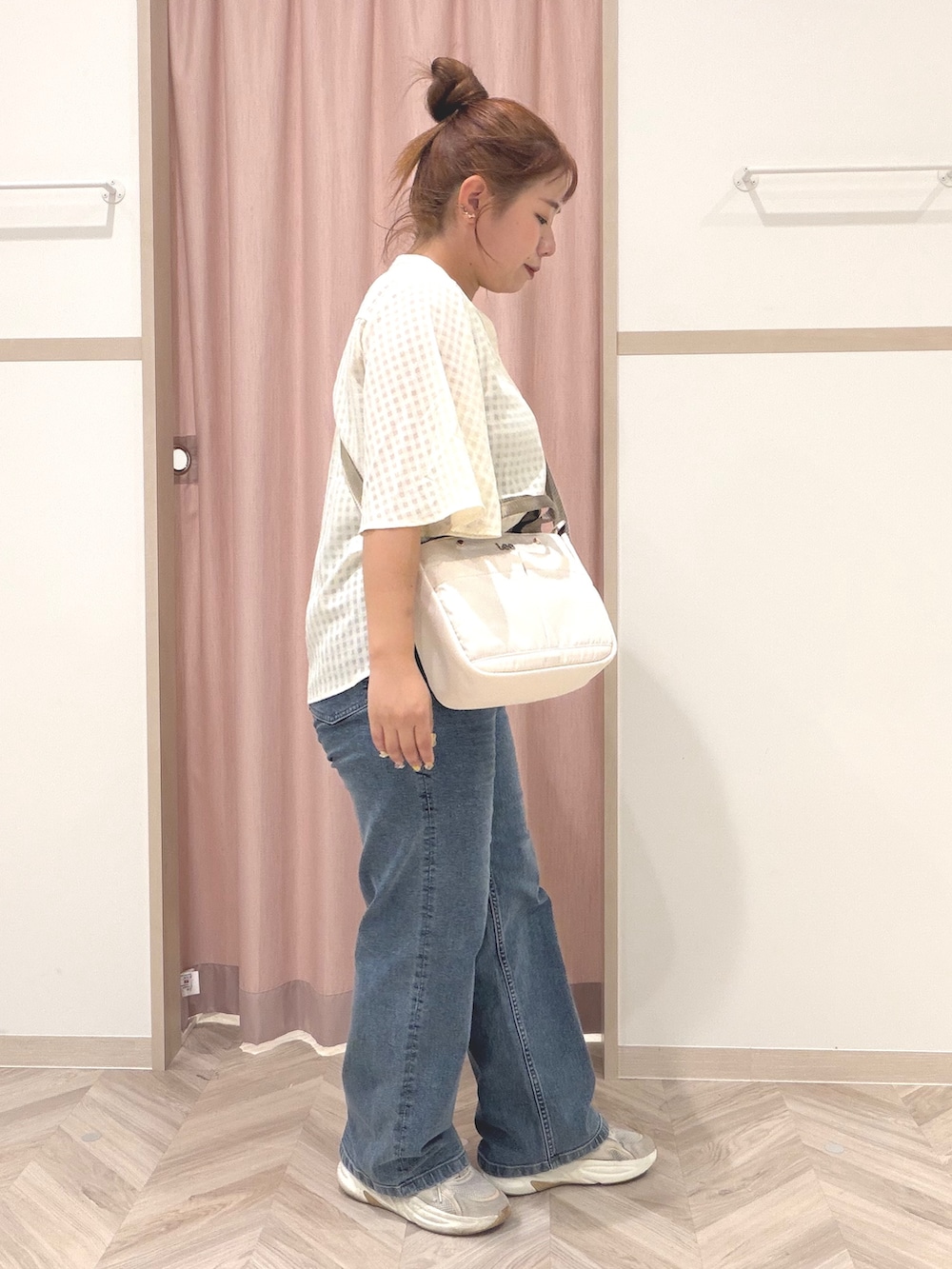 ゴールド系のタンクトップ、ホワイト系のシャツ/ブラウス、ブルー系のデニムパンツを着用したレディースの夏コーディネートの4枚目の写真