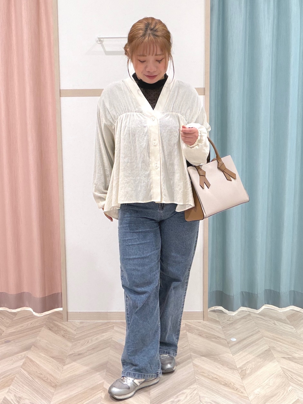 ブラック系のTシャツ/カットソー、ホワイト系のカーディガン/ボレロ、ブルー系のデニムパンツを着用したレディースの秋コーディネートの2枚目の写真