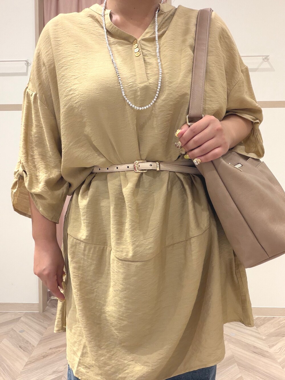 イエロー系のワンピース、ブルー系のデニムパンツ、ベージュ系のショルダーバッグを着用したレディースの夏コーディネートの6枚目の写真