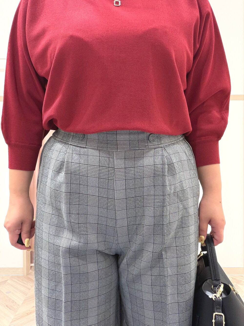 レッド系のニット/セーター、グレー系のその他パンツ、ブラック系のブーツを着用したレディースの秋コーディネートの7枚目の写真
