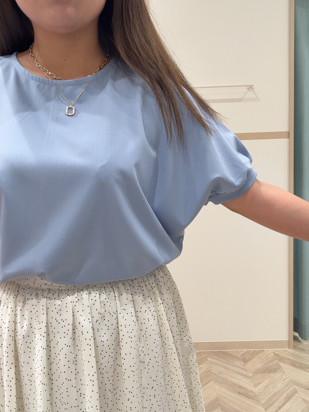 レッド系のニット/セーター、ホワイト系のスカート、ブルー系のシャツ/ブラウスを着用したレディースの春コーディネートの6枚目の写真
