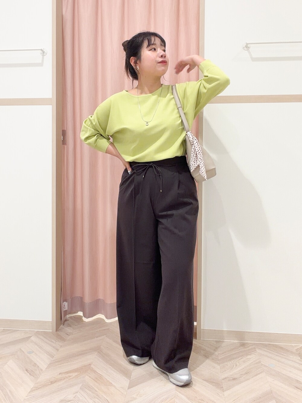 グリーン系のニット/セーター、ブラック系のその他パンツ、ベージュ系のショルダーバッグを着用したレディースの春コーディネートの3枚目の写真